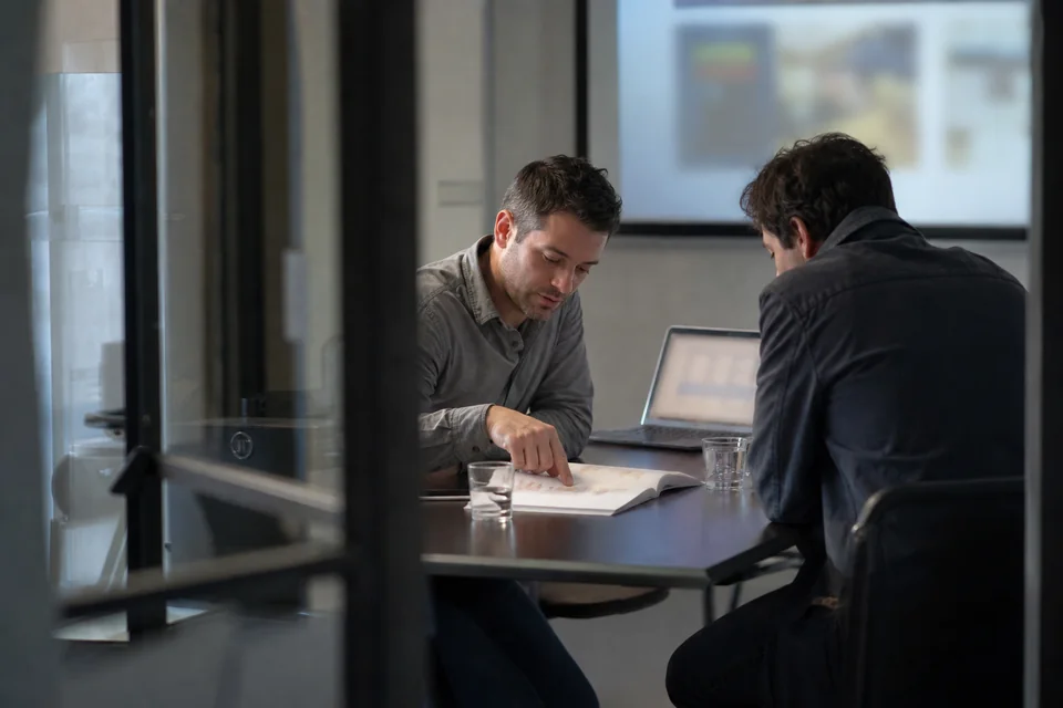 An agency account lead walking a client through a printed white-label report in a small meeting room